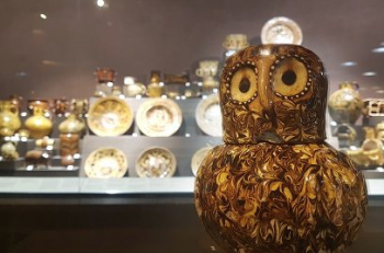 Pottery display with ceramic owl in foreground